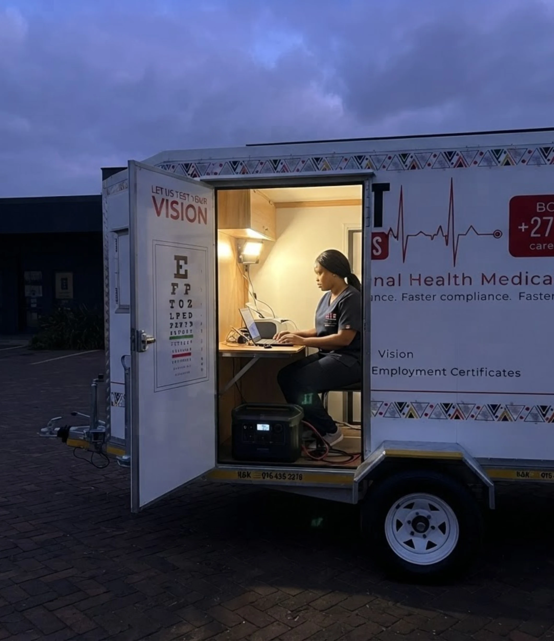 A Care Net mobile clinic lit and working during a power cut, a worker stepping up to the door